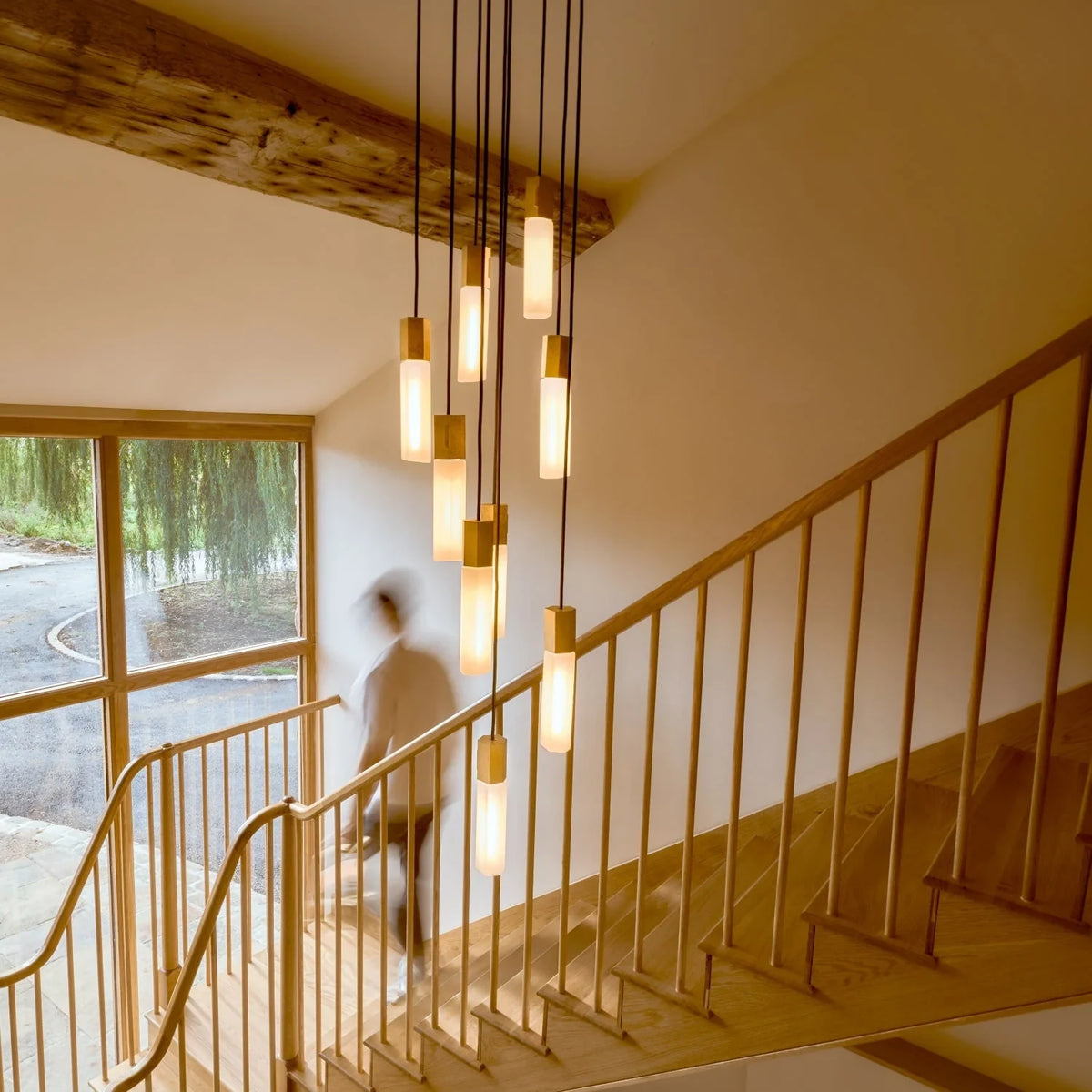 Nine-drop cluster pendant in cast brass with glass bulbs, in a stairwell