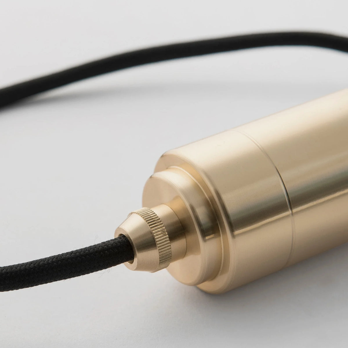 Brass pendant with tinted glass filament bulb, close-up of the brass holder