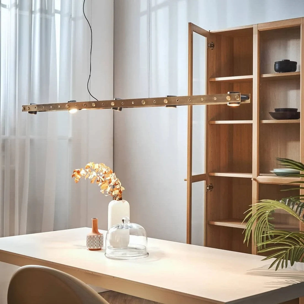 Brass track LED pendant, above a table with flowers
