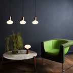 Broad dome matte white glass pendant, graphite, three together above a coffee table