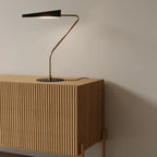 Cantilevered reeded table lamp, on a fluted wooden sideboard