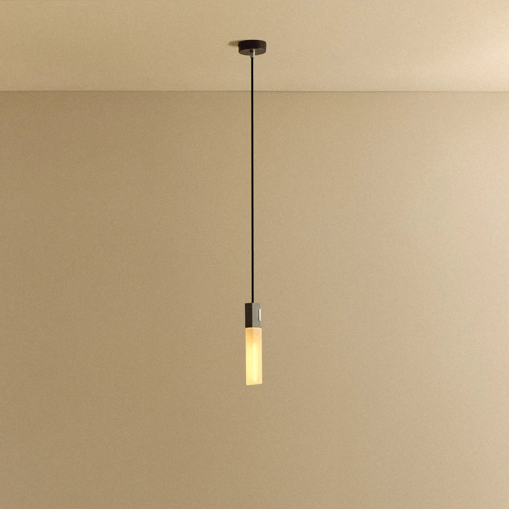 Cast metal hexagonal pendant, on a plain background