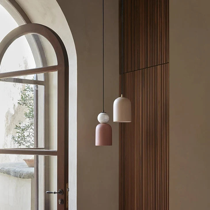 Ceramic bell pendant with marble ball, group hung by an arched window