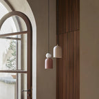 Ceramic bell pendant with marble ball, group hung by an arched window