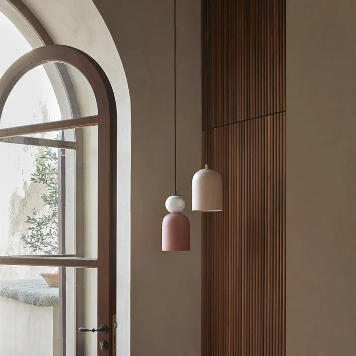 Ceramic bell pendant with marble ball, group hung by an arched window