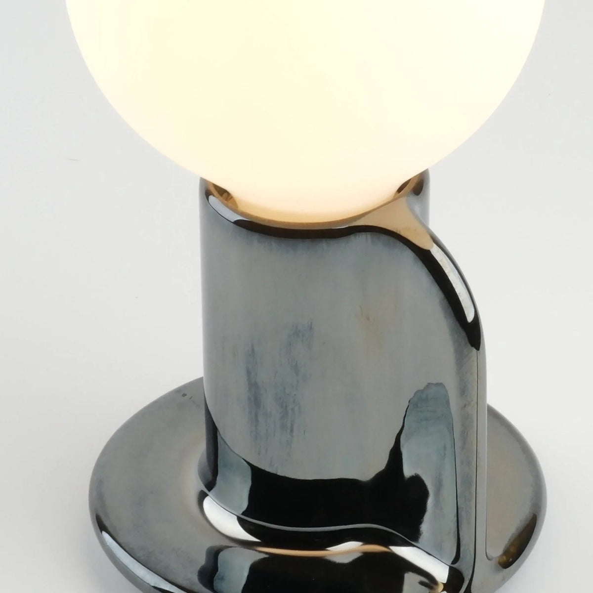 Ceramic table lamp with a paddle handle, in chrome, close-up