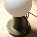 Ceramic table lamp with a paddle handle, in moss, close-up of the base