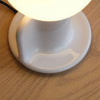 Ceramic table lamp with a paddle handle, in white, close-up of the base