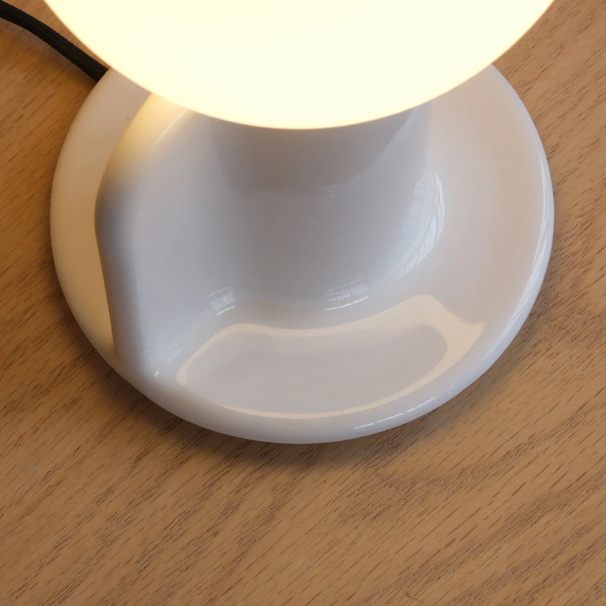 Ceramic table lamp with a paddle handle, in white, close-up of the base