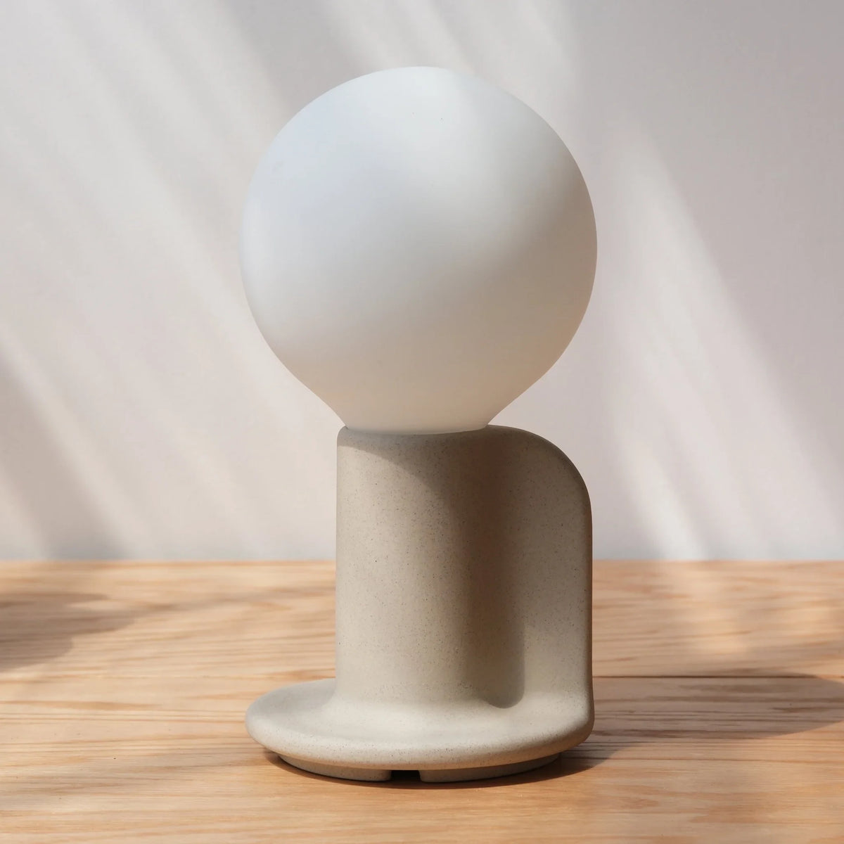 Ceramic table lamp with a paddle handle, in bone