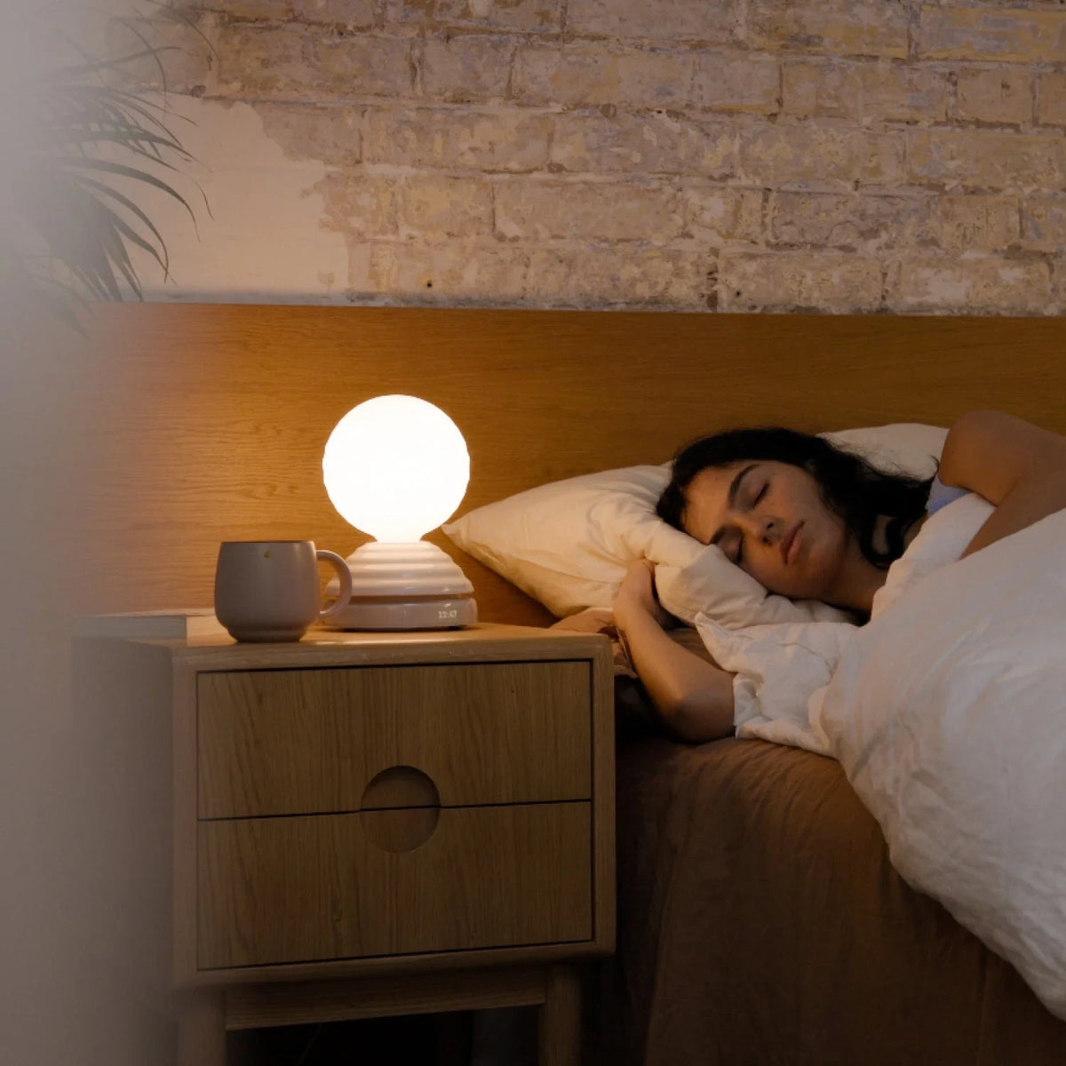 Ceramic wake light lamp pair, beside a sleeping woman