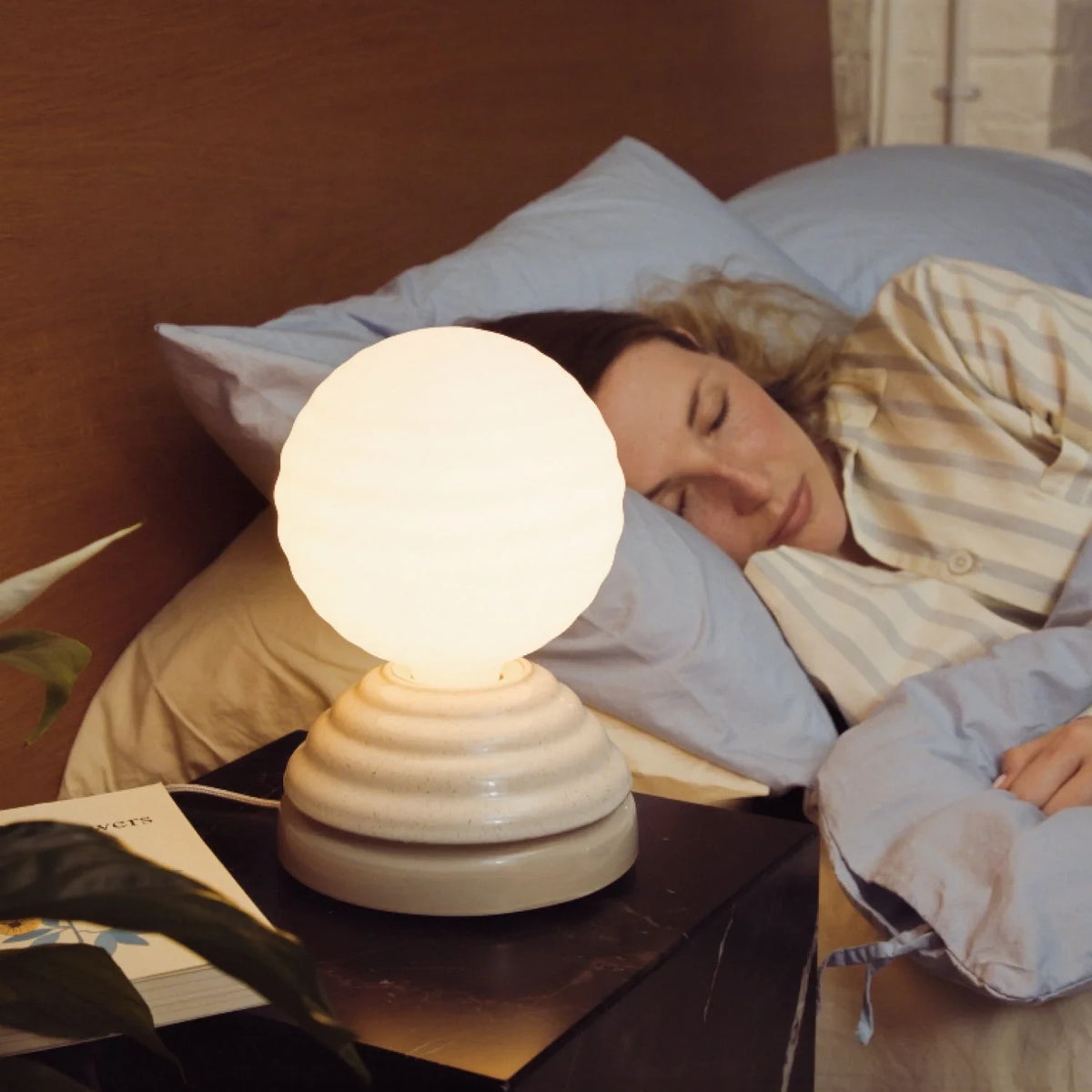 Ceramic wake light lamp pair, beside a woman asleep