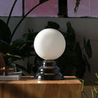 Chrome-glazed rippled table lamp with glass globe, on a wooden block