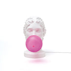 Classical bust table lamp with a pink bubblegum bubble, front view, lit