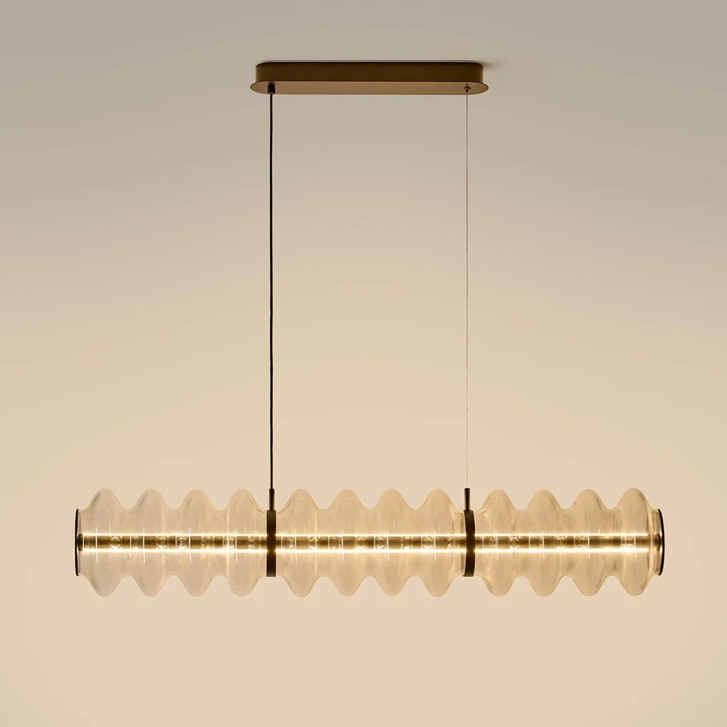 Clear glass disc linear LED pendant, lit, with aged gold canopy
