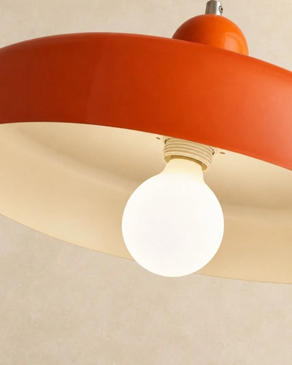 Two-tone disc pendant light, underside of the orange shade with the bulb