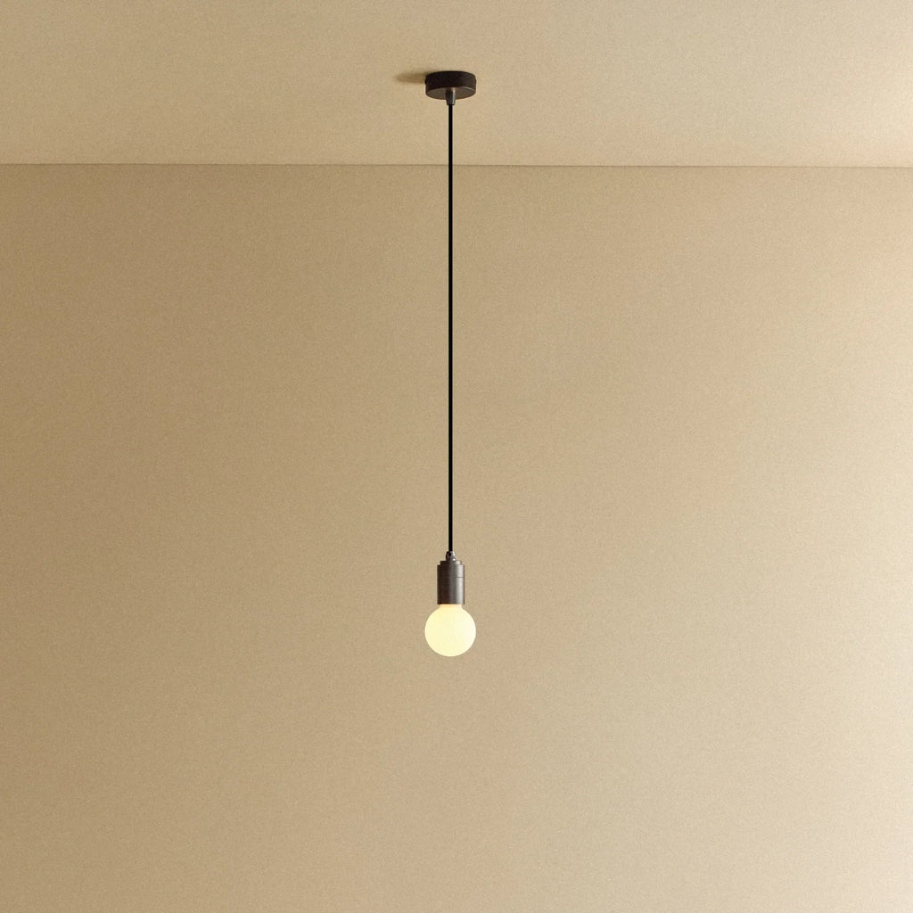 Compact opal globe pendant, dim-to-warm, graphite, lit, hung from the ceiling