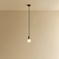 Compact opal globe pendant, dim-to-warm, graphite, lit, hung from the ceiling