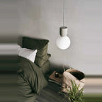 Concrete and glass globe pendant, above a bedside