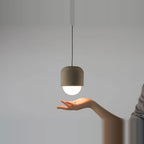 Concrete and opal glass mini pendant, above an open hand