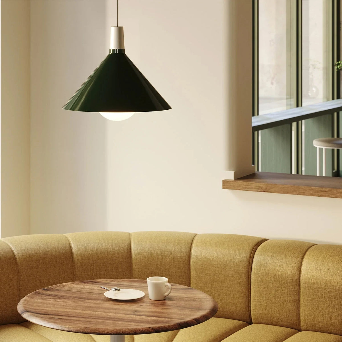 Medium dark green steel pendant with matt white globe bulb, above a round table in a booth corner