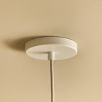Medium dark green steel pendant with matt white globe bulb, close-up of the ceiling canopy