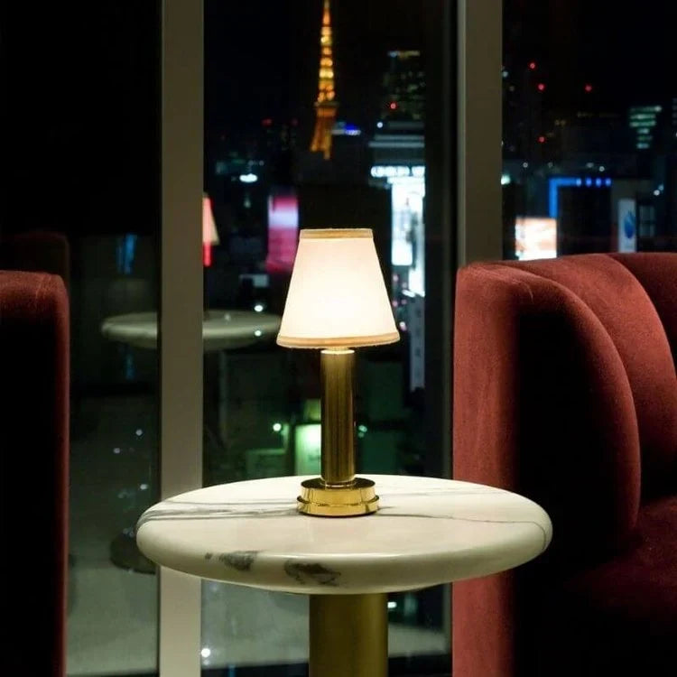 Cordless pleated shade table lamp, lit on a restaurant table