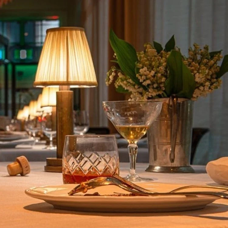 Cordless pleated shade table lamp, lit on a dining table