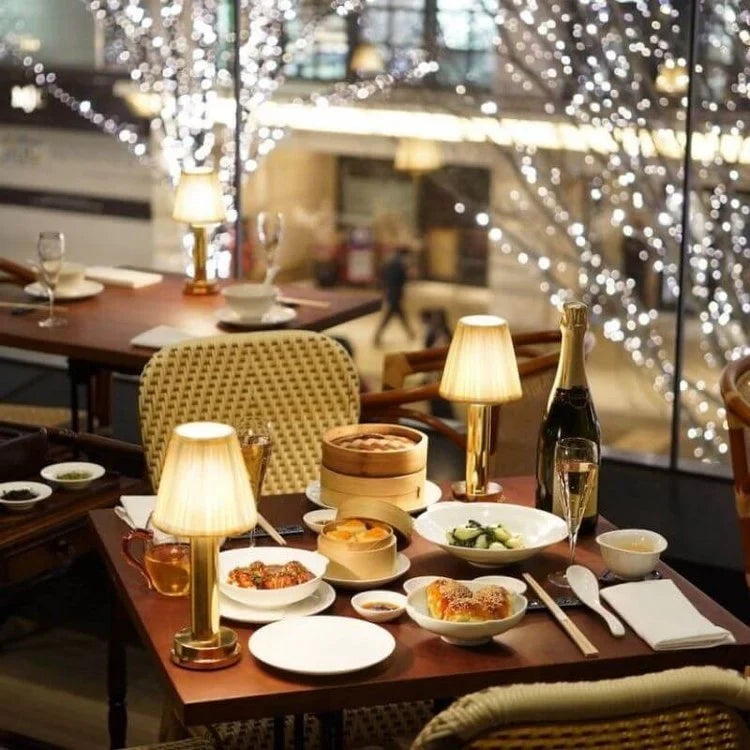 Cordless pleated shade table lamp, lit on a restaurant table
