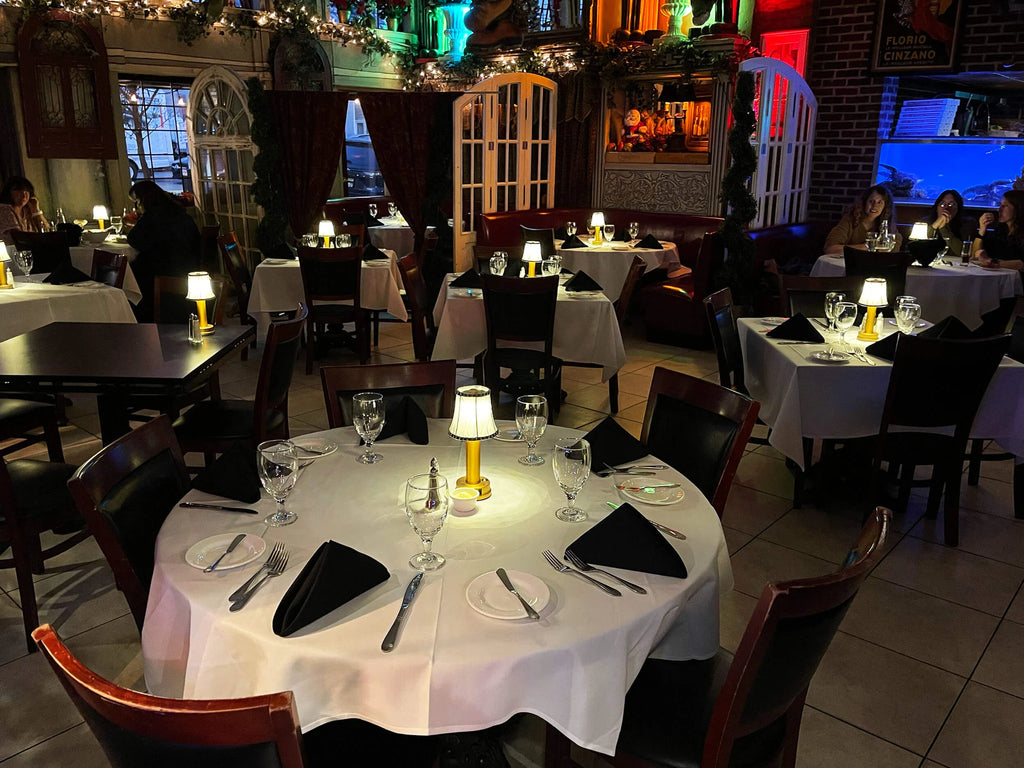 Cordless pleated shade table lamp, lit on a restaurant table