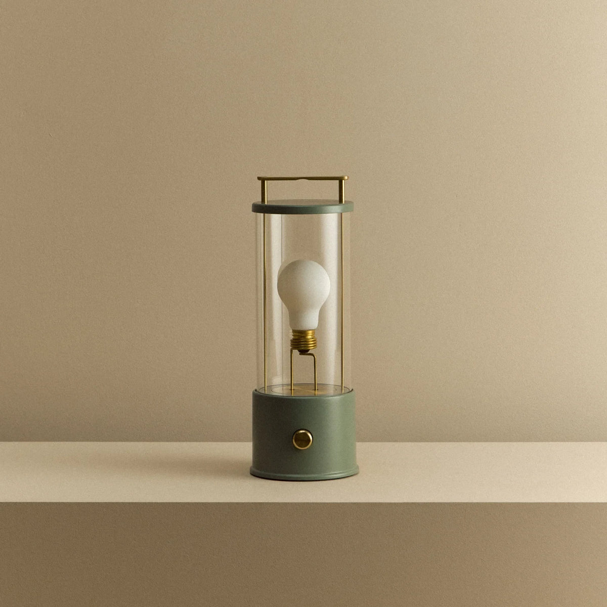 Cordless lantern lamp, green finish, unlit, on a plain ledge