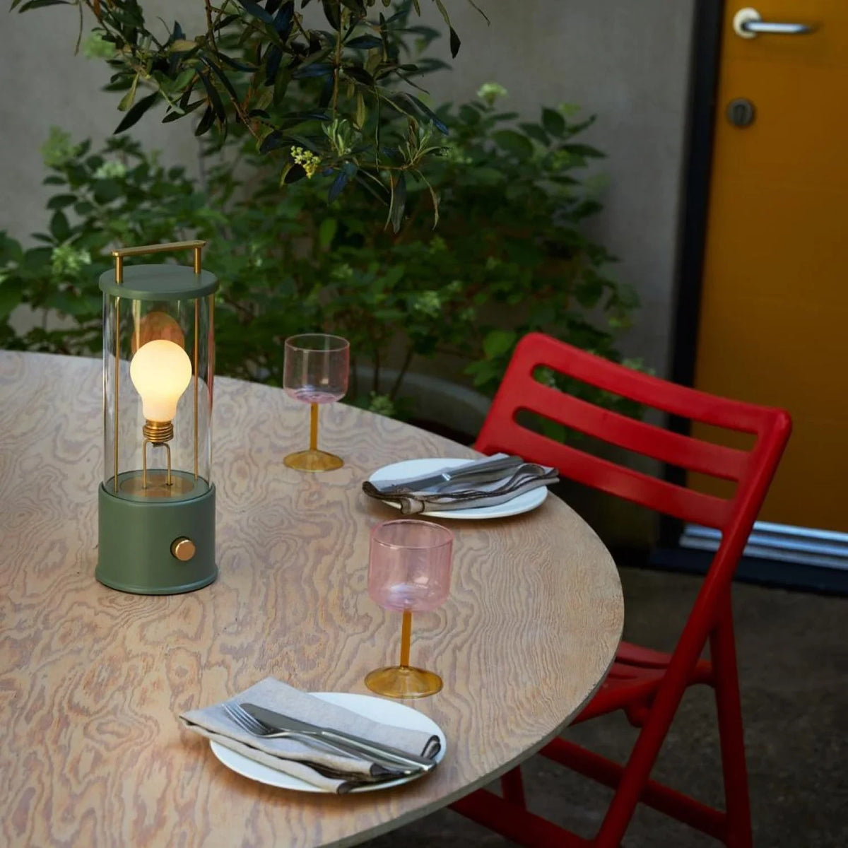Cordless lantern lamp, green finish, on an outdoor café table
