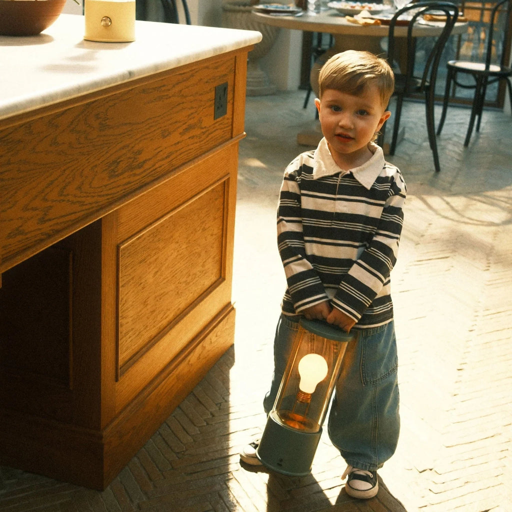 Cordless lantern lamp, green finish, carried by a child