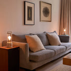 Cordless lantern lamp, plaster pink finish, beside a sofa