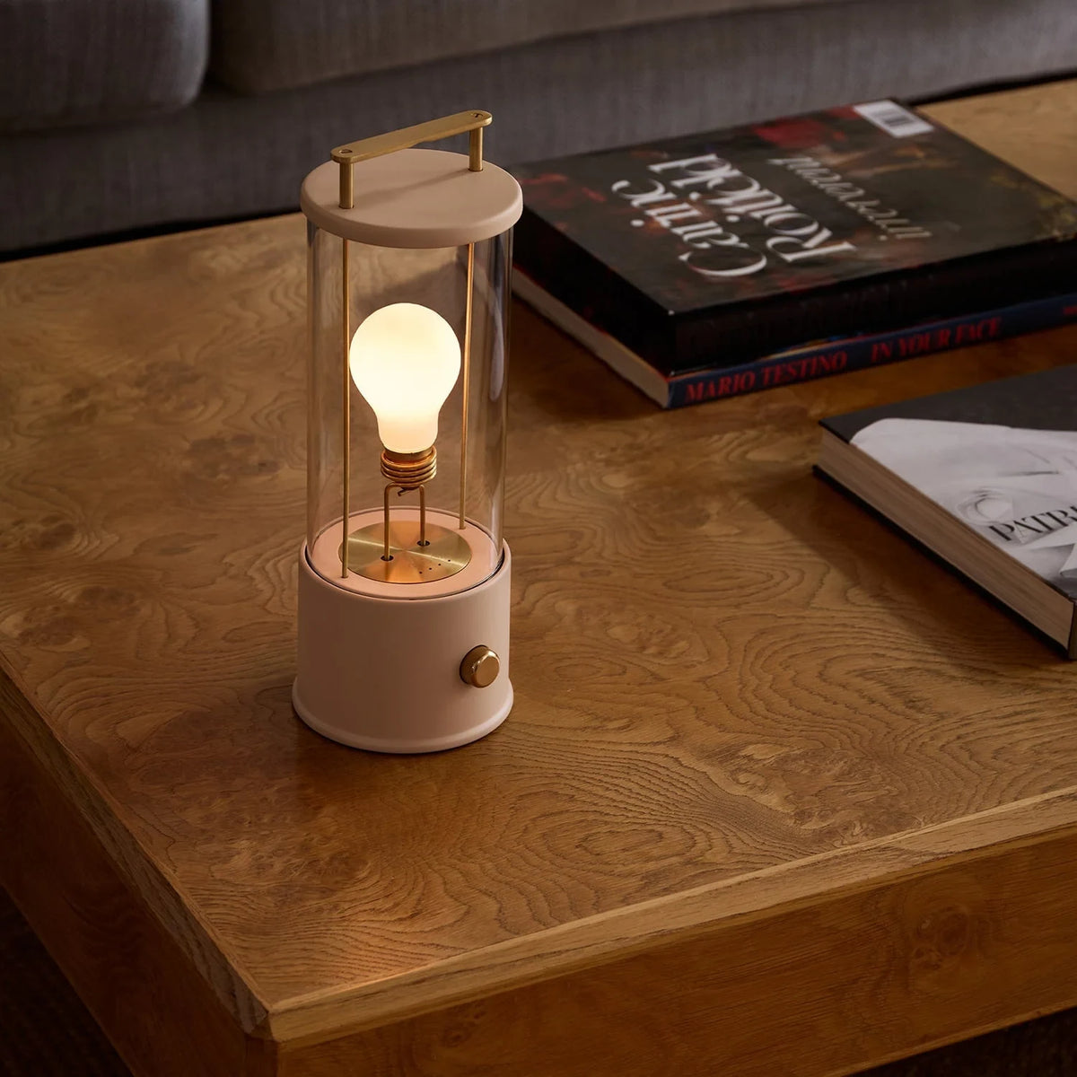 Cordless lantern lamp, plaster pink finish, on a coffee table beside books