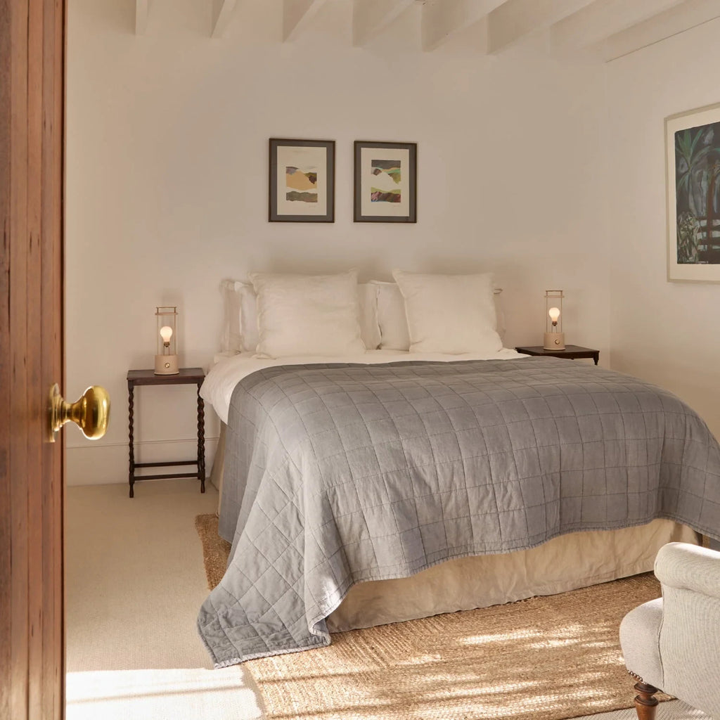 Cordless lantern lamp, plaster pink finish, beside a bed