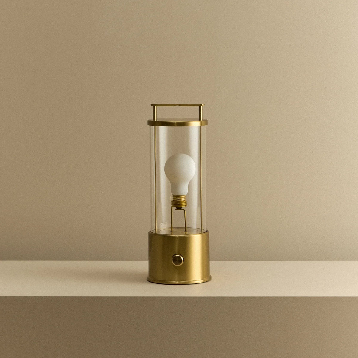 Cordless lantern lamp, solid brass, unlit, on a plain ledge