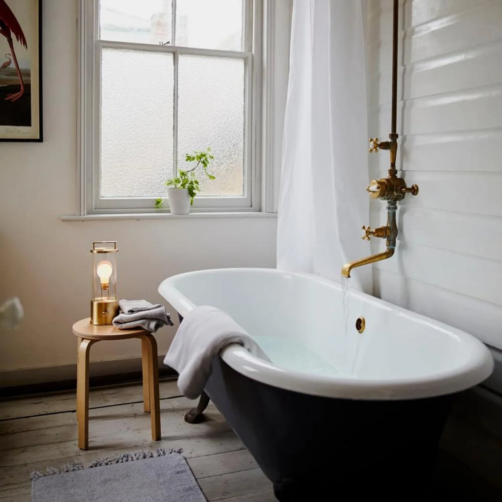 Cordless lantern lamp, solid brass, on a stool beside the bath