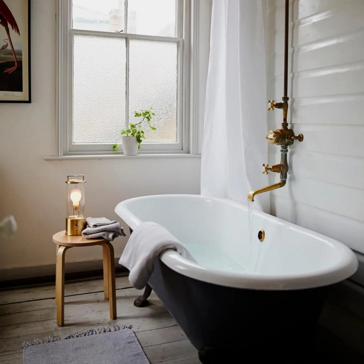 Cordless lantern lamp, solid brass, on a stool beside the bath
