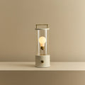 Cordless lantern lamp, white finish, lit, on a plain ledge