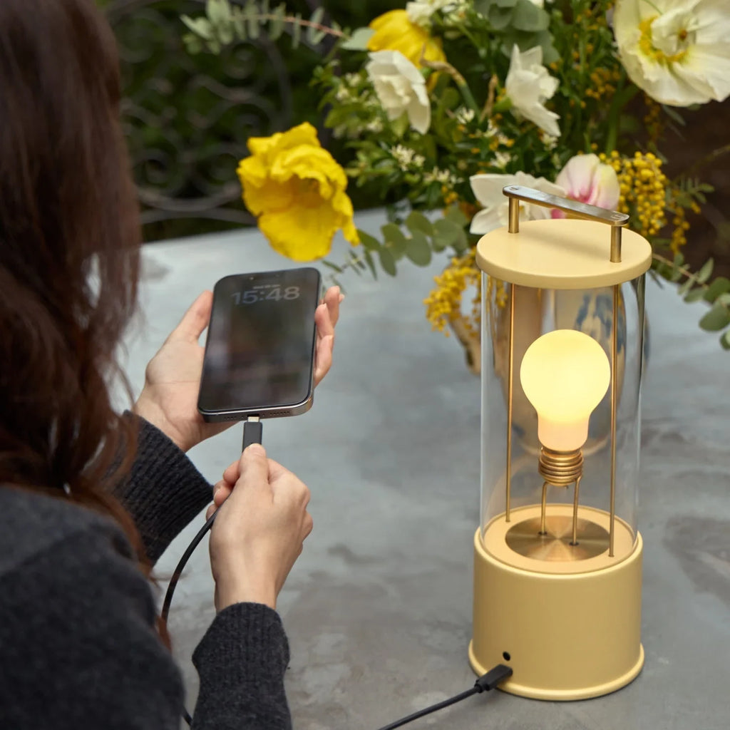 Cordless lantern lamp, yellow finish, charging a phone