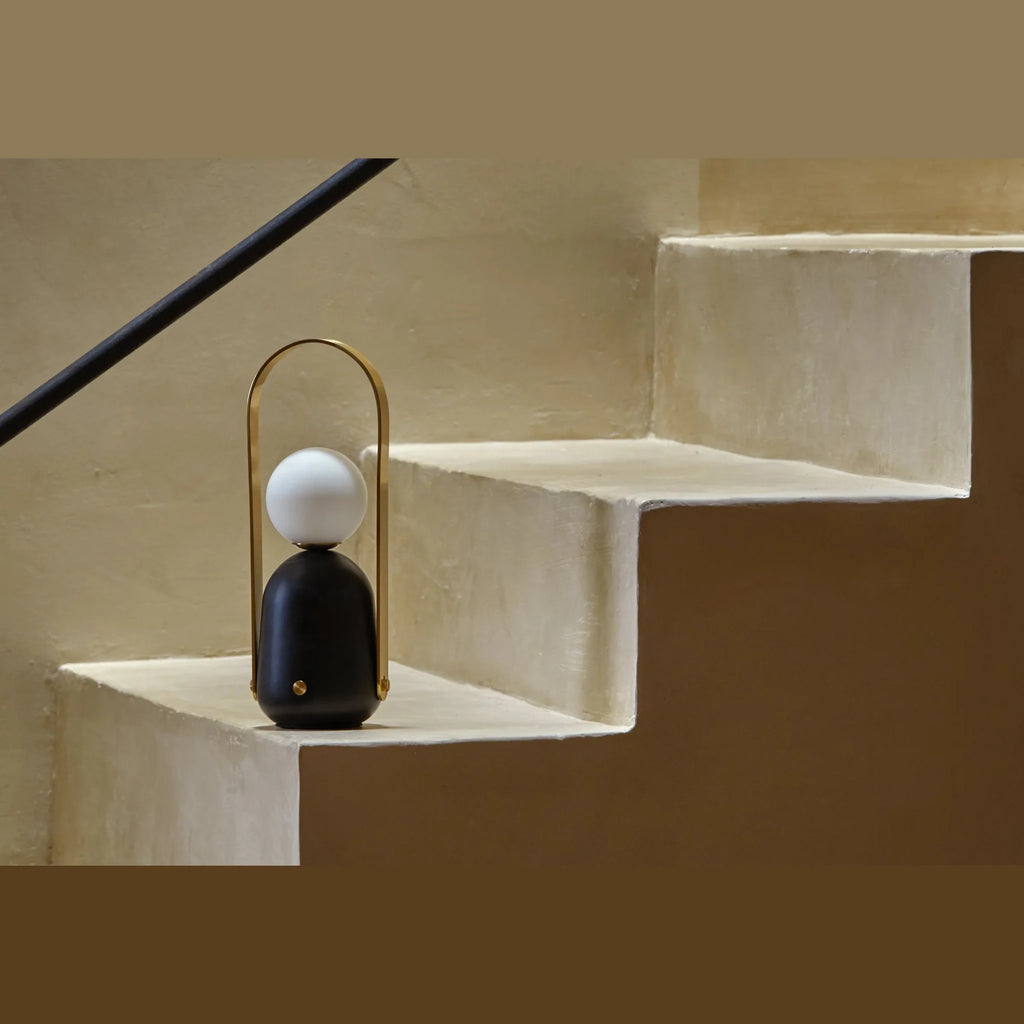 Cordless marble opal globe table lamp, on a stone step
