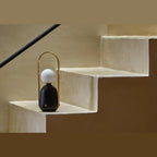 Cordless marble opal globe table lamp, on a stone step
