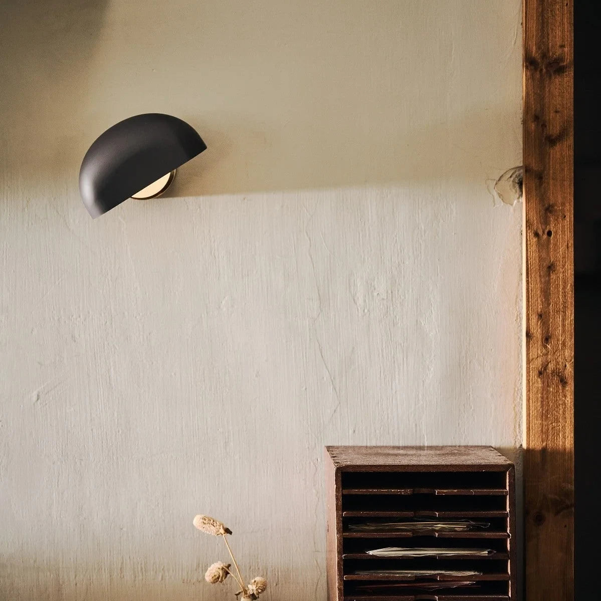 Cordless opal glass table lamp with rotating shade, mounted on a wall