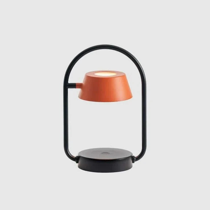 Cordless oval loop table lamp, coral orange, on a plain background