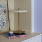 Cordless rechargeable LED table lamp, brass base, in use at home