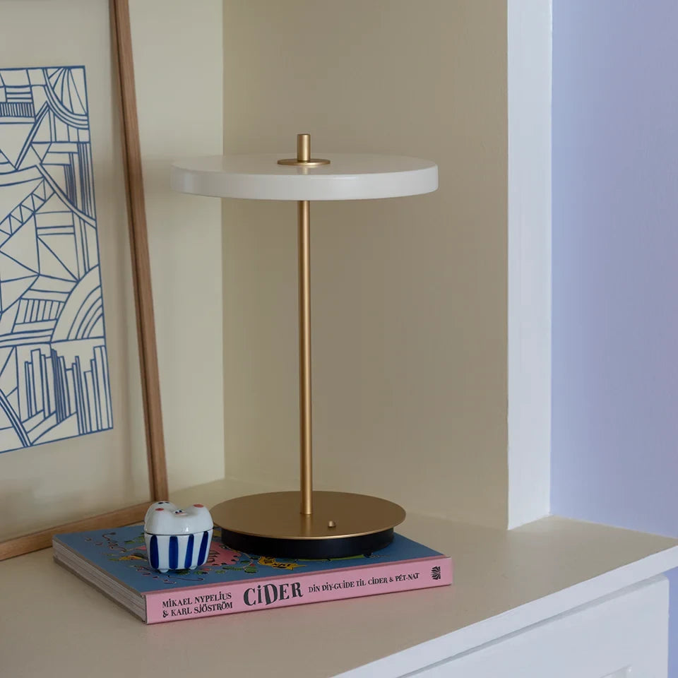 Cordless rechargeable LED table lamp, brass base, in use at home