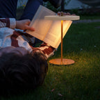Cordless rechargeable LED table lamp, brass base, lit for reading at dusk