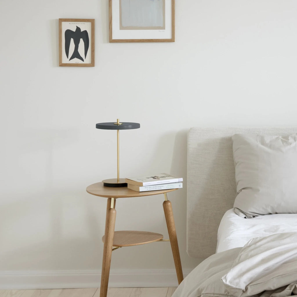 Cordless rechargeable LED table lamp, brass base, beside a bed