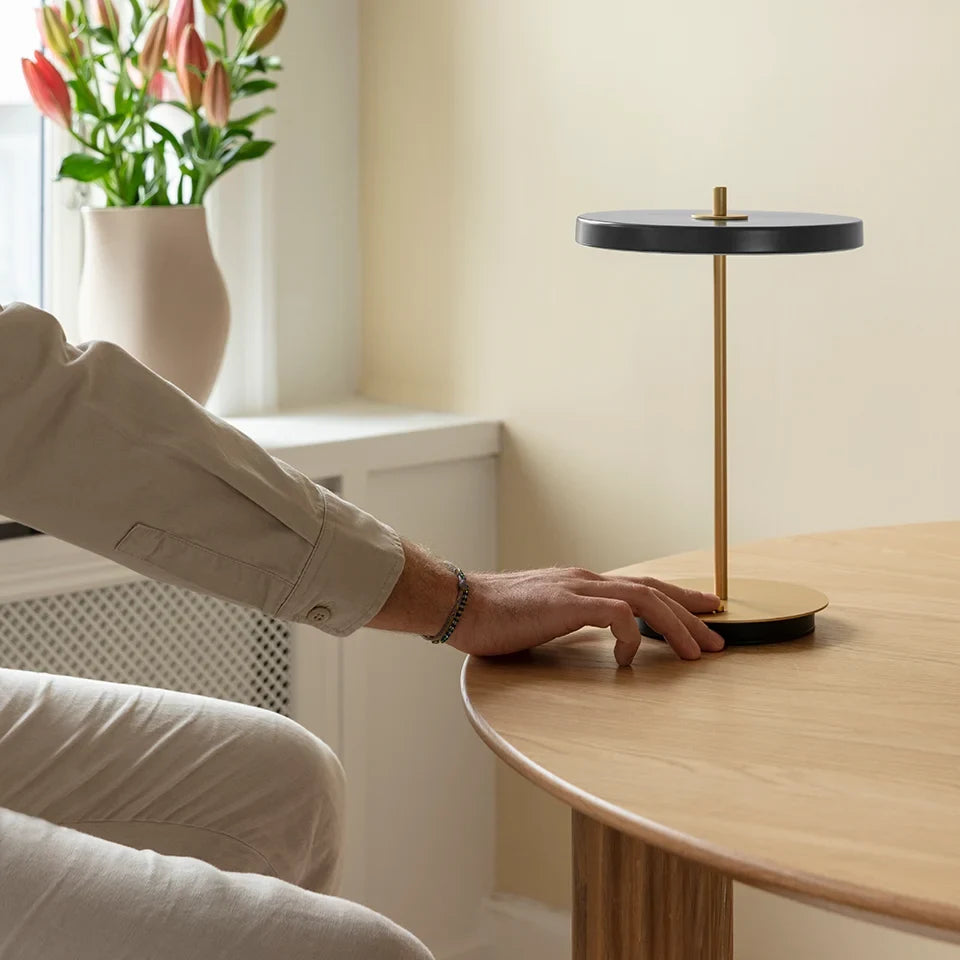 Cordless rechargeable LED table lamp, brass base, in use at home